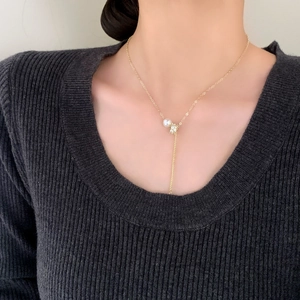 Minimalist Y-shaped necklace with pearl and pavé zircon tassel worn by a model