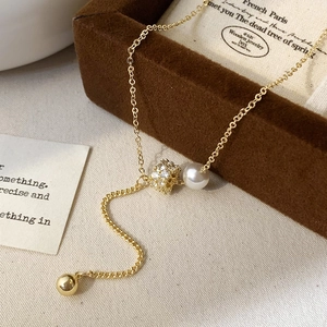 Elegant gold-tone Y-necklace featuring a white pearl, zircon bead and polished gold sphere