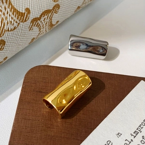 Detailed view of polished gold and silver metal ear cuffs with irregular texture