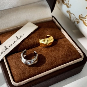 Irregular textured gold and silver ear cuffs displayed in a premium velvet jewelry box