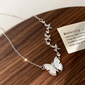 Détail du collier papillon argenté élégant avec pendentif en nacre et zircons