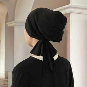 Detail view of the pleated back and long adjustable ties of the black turban hat