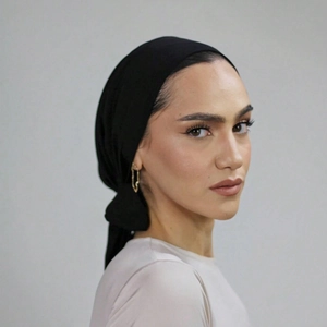 Detail of elegant black pleated turban showing high-quality fabric and back knot detail