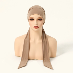 Detail of khaki crystal linen turban with long straps and pleated elastic fabric texture
