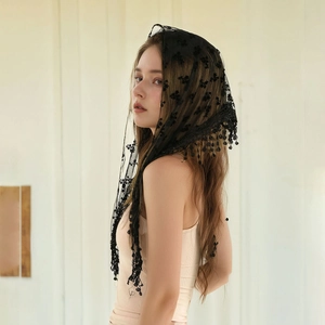 Close-up of black floral lace bridal veil with fringe tassels and delicate embroidery