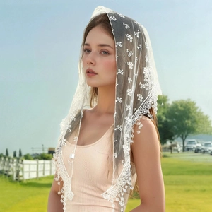 Detailed close-up of white floral lace bridal veil with delicate embroidery and beaded trim