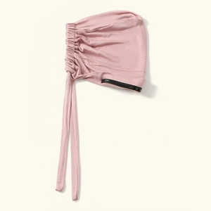 Primo piano dettaglio cuffia elastica rosa da donna, tessuto elasticizzato morbido tinta unita.