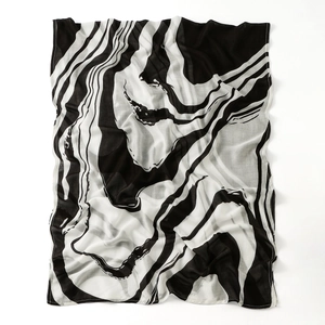 Detail of soft marble print scarf with black and white fluid art pattern and rolled hems