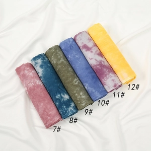 Vue détaillée d'écharpes en coton tie-dye aux teintes vives de rose, bleu et olive
