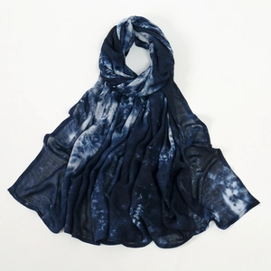Détail d'un châle léger en viscose tie-dye avec motifs dégradés bleu profond et blanc