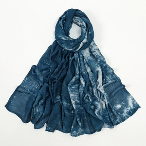 Détail d'une écharpe en rayonne tie-dye bleu et blanc montrant un dégradé doux et froissé