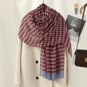 Floral print voile shawl in burgundy with blue geometric border draped on a white coat
