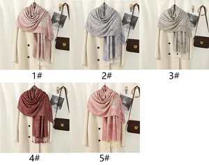 Macro detail of various paisley pattern pashmina scarves with elegant tassel fringe
