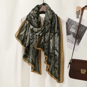 Elegant long leaf print scarf for women with tropical leaves on dark green fabric