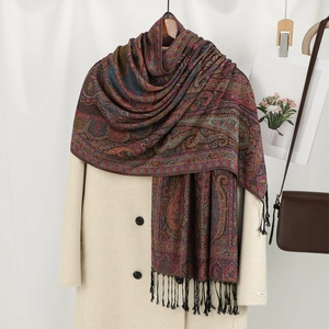 Ethnic paisley jacquard shawl with tassels styled over a classic beige trench coat