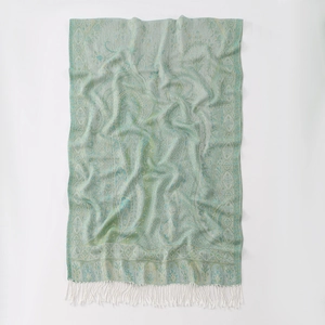 Detail of light green paisley jacquard shawl with delicate white fringe tassels