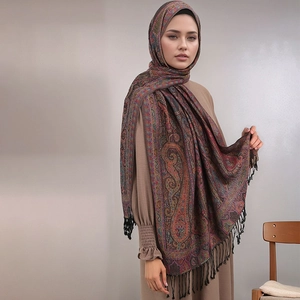 Detail of bohemian paisley shawl with long fringe tassels on high-quality fabric