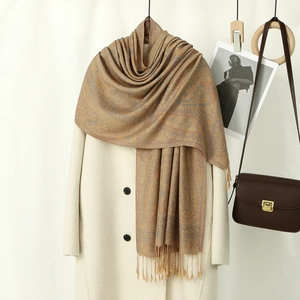 Détail d'un châle jacquard cachemire à motifs paisley avec franges et tons camel chauds