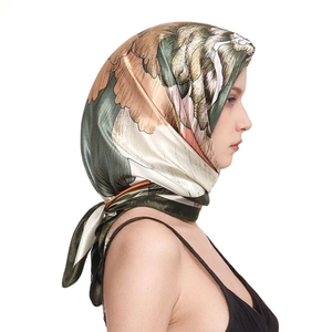Close-up of floral print satin square scarf with olive and orange pattern and hand-rolled edges