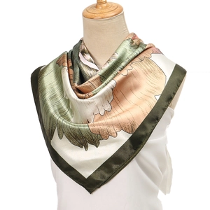 Close-up of lightweight satin floral square scarf with olive green and salmon pink print