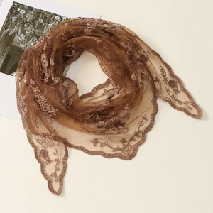 Detailed close-up of brown floral embroidery and hollow lace edges on soft mesh fabric