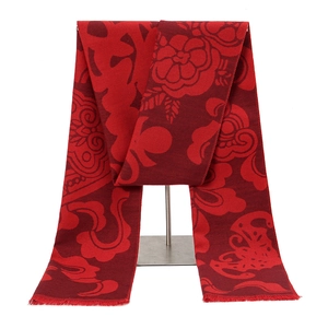 Detail of red polyester scarf showing traditional floral jacquard patterns and fringe edges