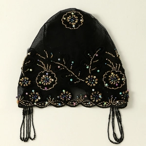 Detail eines schwarzen Vintage-Spitzenturbans mit Goldperlen und Blumenpailletten