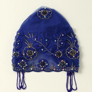 Detail eines königsblauen Spitzen-Turban mit handgefertigter 3D-Blume und Perlenfransen
