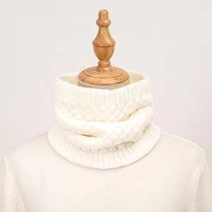 Detail van gebreide off-white nekwarmer met kabelpatroon en geribbelde randen