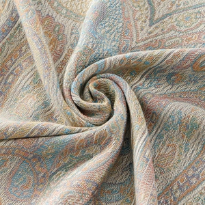 Close-up of intricate paisley jacquard weave and fabric texture on a bohemian shawl