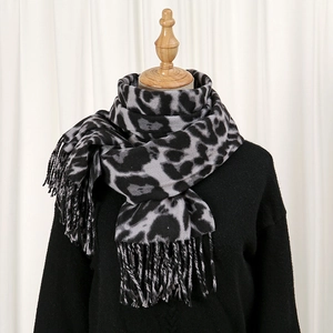 Detail of gray leopard print winter scarf with tassels and soft cashmere-like texture