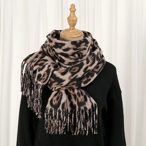 Close-up of leopard print scarf texture with thick cashmere-like fabric and fringe detail