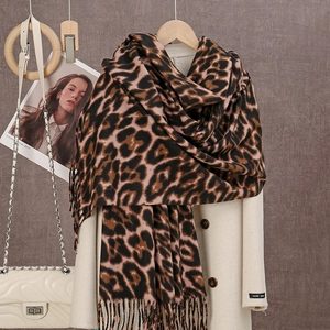 Detail of soft leopard print scarf with long fringe tassels paired with winter coat