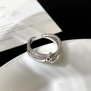 Detailed view of silver crossover ring featuring micro-pave white zircon crystals