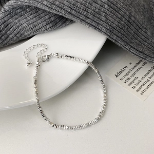 Detail of silver pearl bracelet with lobster clasp and extender chain on a white ceramic tray
