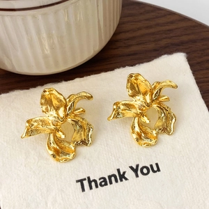 Boucles d'oreilles iris dorées élégantes avec texture métallique sur carte blanche