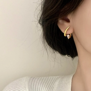 Elegant gold claw ear cuff with snake-like texture and a teardrop zircon gemstone