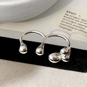Macro view of a silver double-finger ring with a liquid metal flow aesthetic on black velvet
