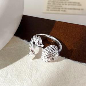 Primo piano dettagliato di un anello regolabile in argento con motivi di conchiglie e crostacei