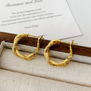Detailed view of twisted gold hoop earrings with S925 sterling silver post hallmark