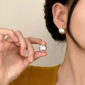 Boucles d'oreilles boules argentées avec texture brossée et finition minimaliste chic