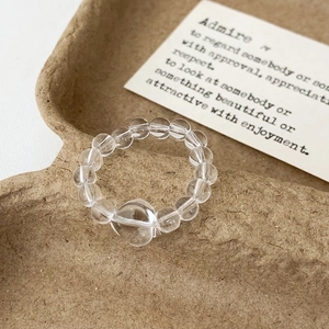Macro shot of minimalist clear glass beaded ring featuring a heart-shaped centerpiece