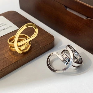 Minimalist entwined gold and silver open rings with polished fluid metallic design