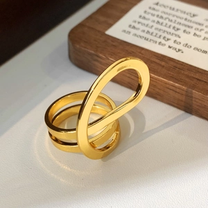 Close-up of gold interlocking triple-layer ring featuring a minimalist geometric design