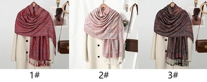Three variants of Paisley floral scarves with tassels displayed on a white coat backdrop