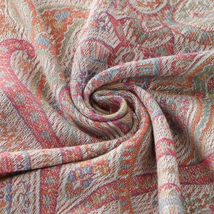 Detailed macro view of paisley jacquard pattern with tassel fringe on soft polyester scarf