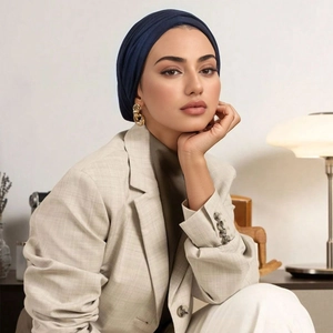 Detail of elegant dark blue mercerized cotton turban styled with a beige blazer jacket