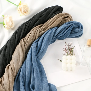Details von drei plissierten Schals in Schwarz, Kamel und Jeansblau mit weicher Struktur