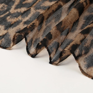 Macro detail of leopard print voile scarf showing sheer texture and fine edge stitching
