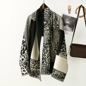 Detail showing soft leopard print scarf with fringe edges and classic herringbone pattern